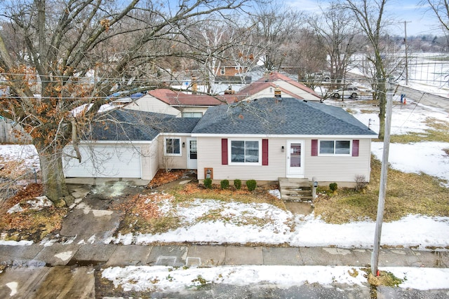 view of front of house featuring a garage, roof with shingles, and driveway