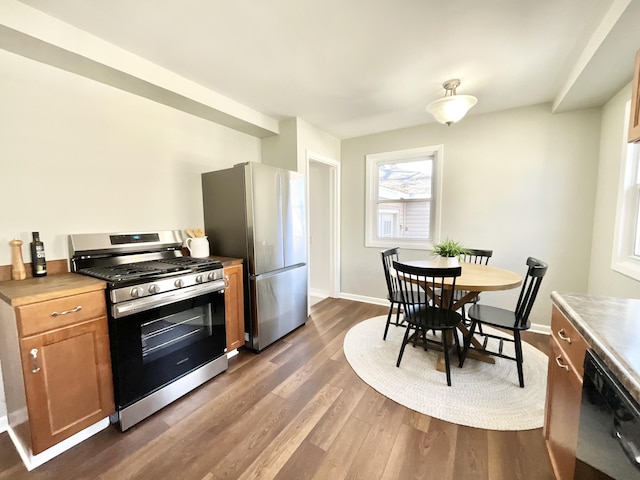 kitchen with brown cabinets, dark wood-style floors, baseboards, and stainless steel appliances