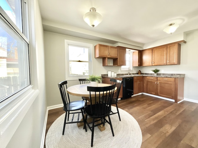 kitchen with dark wood-style floors, baseboards, brown cabinetry, and dishwasher