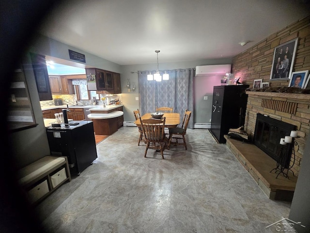 dining area featuring a chandelier, a baseboard heating unit, a wall unit AC, and a fireplace