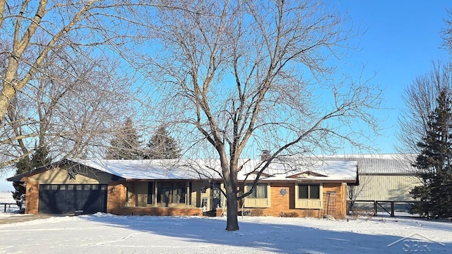 ranch-style home with a garage and a chimney