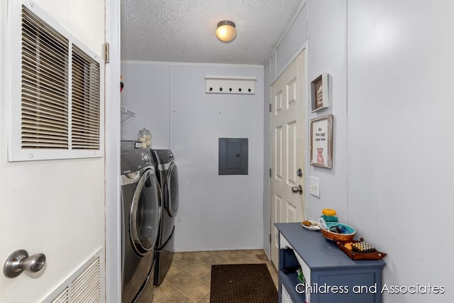 laundry area featuring washing machine and dryer, laundry area, electric panel, and a textured ceiling