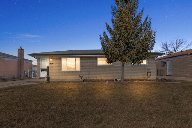 view of front of house with brick siding and a front yard