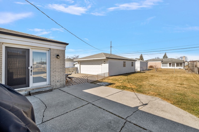 view of patio / terrace featuring a garage, an outbuilding, and fence