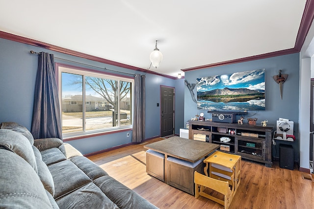 living area featuring baseboards, ornamental molding, and wood finished floors