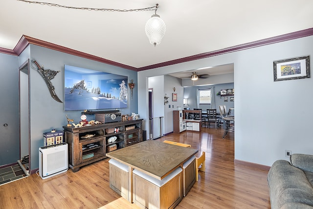 interior space featuring light wood-style floors, baseboards, ornamental molding, and ceiling fan