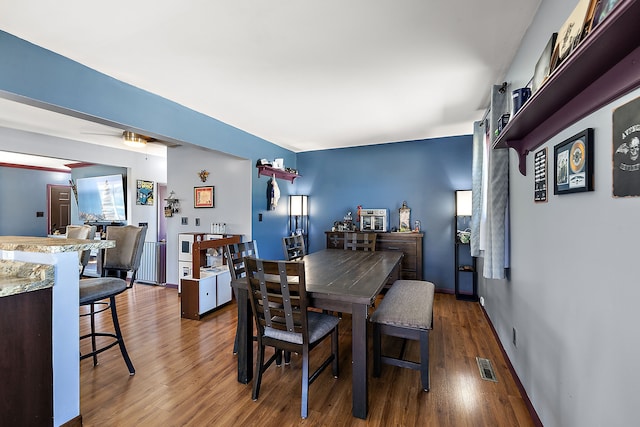 dining space featuring wood finished floors, visible vents, and baseboards