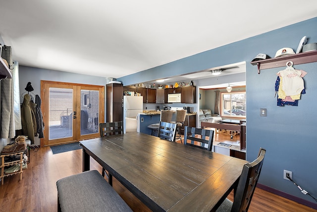 dining space featuring ceiling fan, baseboards, wood finished floors, and french doors