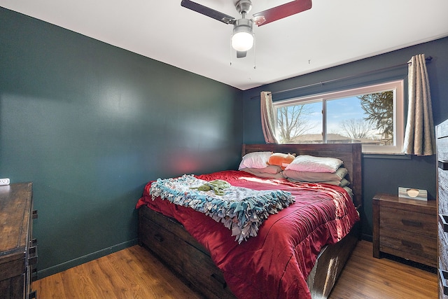 bedroom featuring ceiling fan, wood finished floors, and baseboards