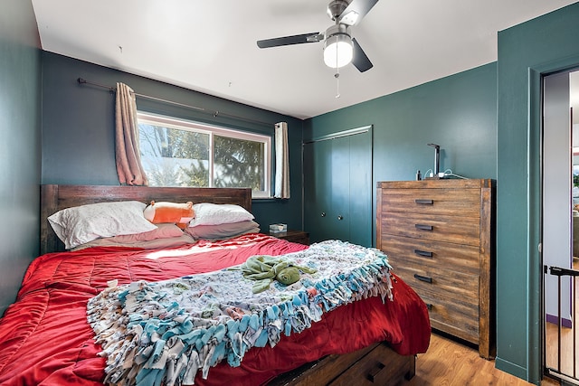 bedroom with a ceiling fan, a closet, and wood finished floors