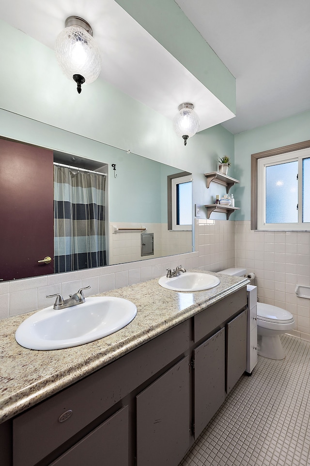 full bathroom with a sink, tile walls, and tile patterned floors