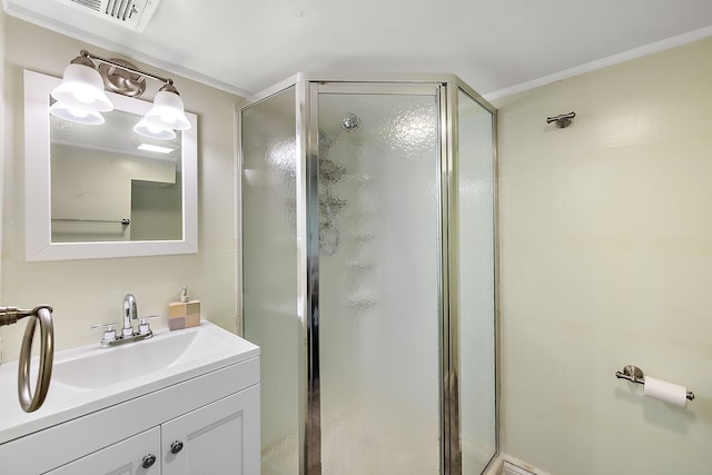 bathroom with vanity, ornamental molding, a shower stall, and visible vents