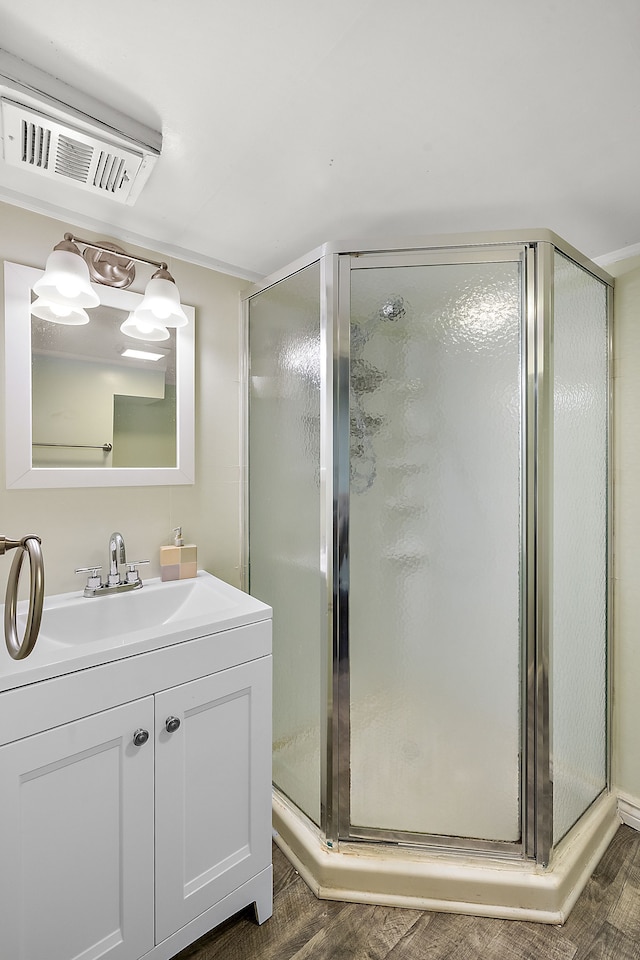 full bath with a stall shower, wood finished floors, and visible vents