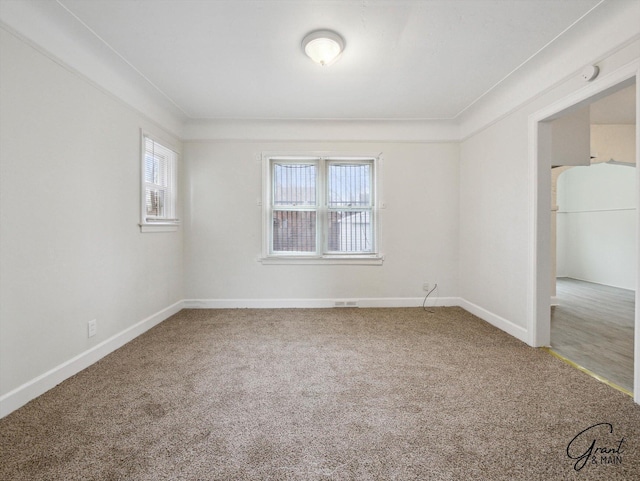 spare room featuring carpet and baseboards