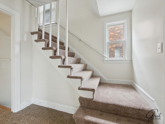 stairs featuring carpet and baseboards