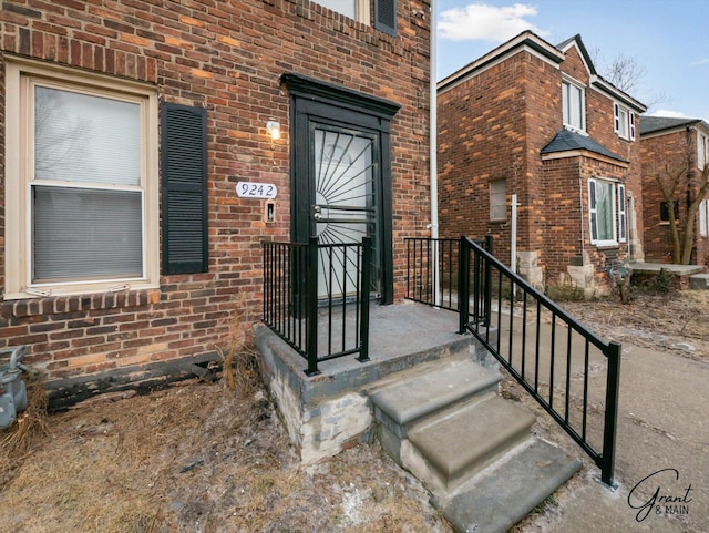 view of exterior entry featuring brick siding