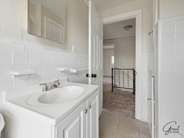 bathroom with tile patterned flooring, a wainscoted wall, tile walls, and vanity