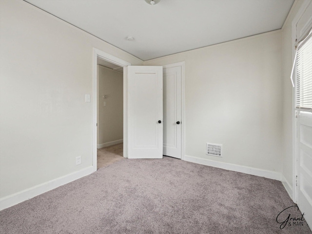 unfurnished bedroom featuring carpet, visible vents, and baseboards