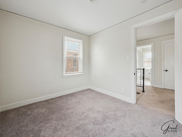 carpeted empty room featuring baseboards