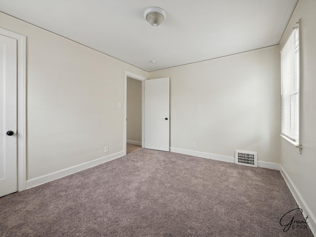 unfurnished bedroom with carpet floors, visible vents, and baseboards