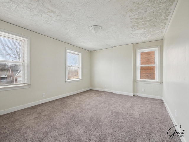 unfurnished room featuring carpet flooring, a textured ceiling, and baseboards