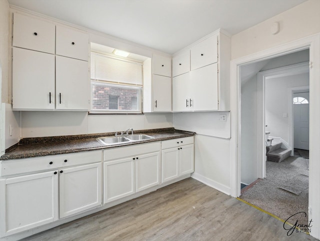 kitchen with a wealth of natural light, light wood-style flooring, a sink, and white cabinetry