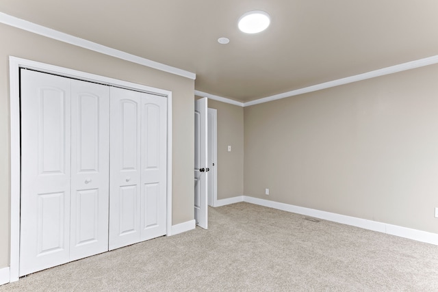 unfurnished bedroom with crown molding, a closet, baseboards, and light colored carpet