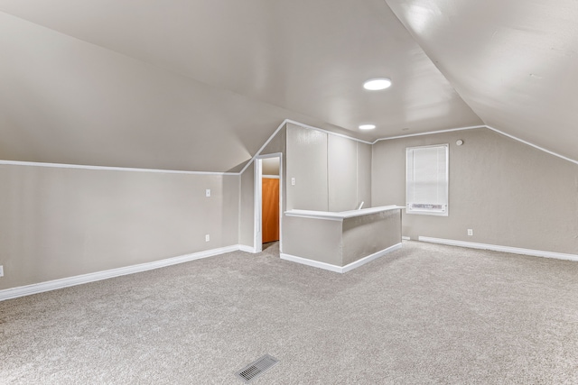 additional living space with carpet, baseboards, and vaulted ceiling