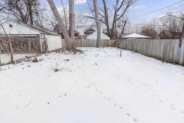 yard layered in snow featuring fence