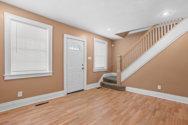 foyer featuring wood finished floors, visible vents, baseboards, recessed lighting, and stairs