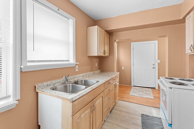 kitchen with light brown cabinets, white range with electric cooktop, a sink, light wood finished floors, and light countertops