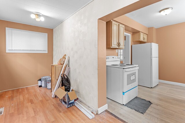 kitchen featuring visible vents, light brown cabinets, baseboards, light wood-type flooring, and white appliances