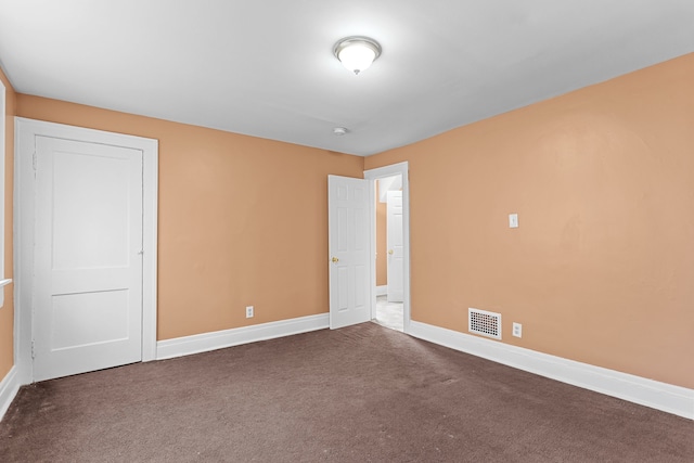 carpeted spare room with visible vents and baseboards