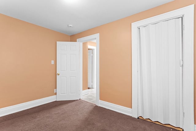 unfurnished bedroom with a closet, baseboards, and carpet floors