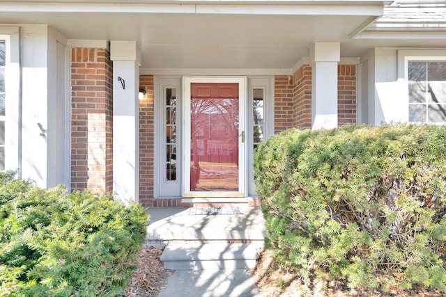 entrance to property featuring brick siding and a porch