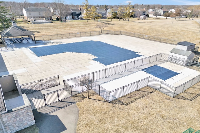 pool featuring a gazebo, fence, a patio area, and a residential view