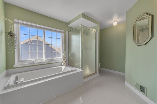 bathroom featuring tile patterned flooring, visible vents, a stall shower, and a garden tub