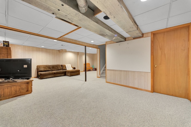 living room featuring a drop ceiling, wood walls, stairs, carpet floors, and recessed lighting