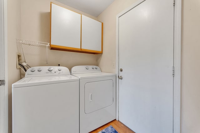 clothes washing area featuring cabinet space, washer and dryer, and light wood-style floors