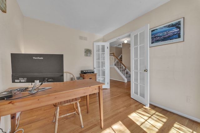 office space with visible vents, light wood-style flooring, french doors, and baseboards