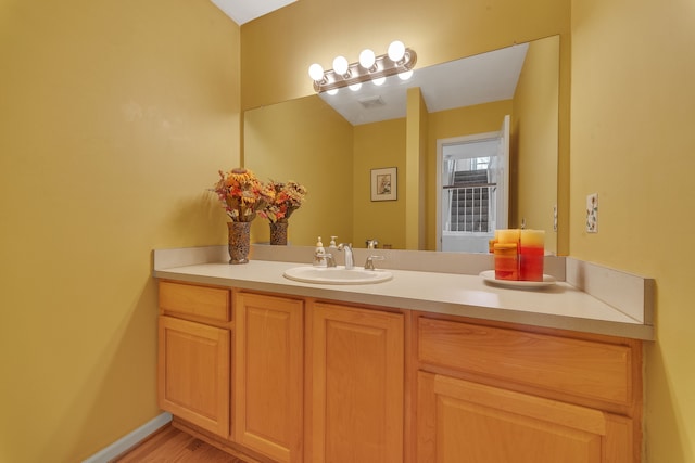 bathroom featuring visible vents, baseboards, and vanity