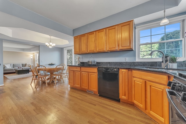 kitchen with brown cabinets, a sink, black dishwasher, light wood finished floors, and a raised ceiling