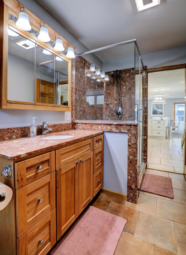 full bath featuring a stall shower, vanity, and tile patterned floors