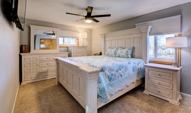 carpeted bedroom with ceiling fan and baseboards