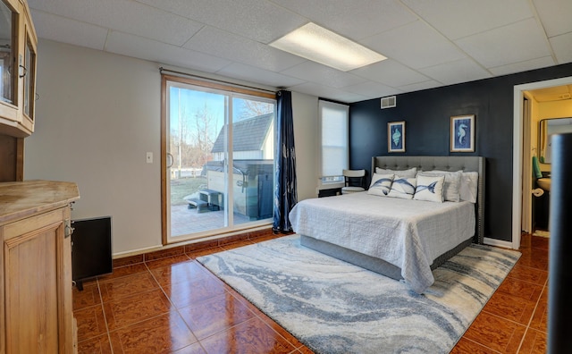 bedroom with visible vents, baseboards, access to exterior, a paneled ceiling, and dark tile patterned floors