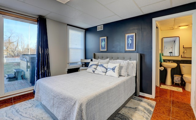 tiled bedroom with visible vents, ensuite bathroom, a drop ceiling, and multiple windows