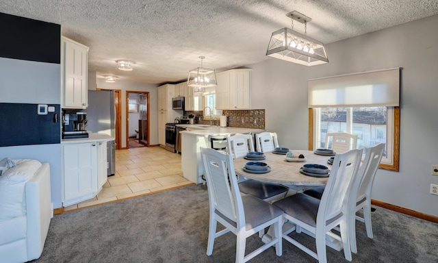 dining space with light carpet, a textured ceiling, baseboards, and light tile patterned floors