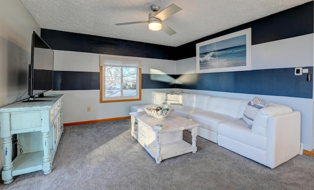 living room with a textured ceiling, carpet floors, a ceiling fan, and baseboards