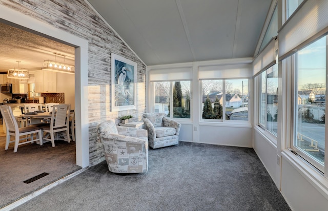 unfurnished sunroom with a chandelier, lofted ceiling, and visible vents