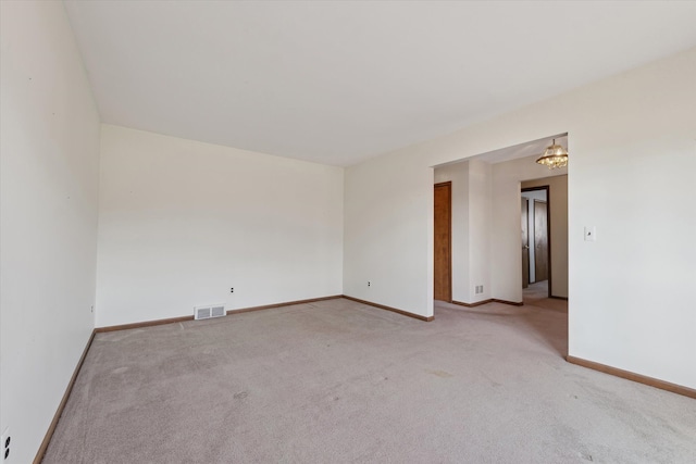 empty room featuring visible vents, light carpet, and baseboards